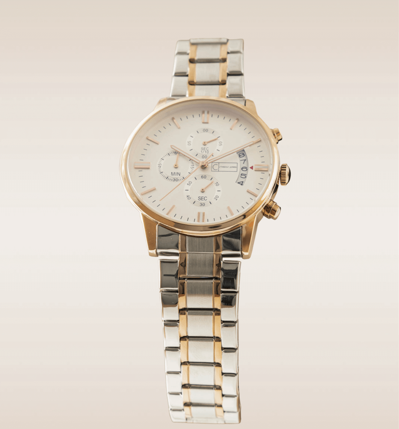 In this up-close shot, we are presented with the captivating Rose Gold Chariot Timepiece, an exquisite blend of elegance and luxury. The watch features a cream-colored watch face that exudes a sense of refined sophistication. The face is encased in shimmering rose gold, adding a touch of opulence and timeless beauty. The watch hands, also in rose gold, move gracefully across the face, marking the passage of time with precision. Complimenting the golden accents, the band is crafted with a silver link design, which adds a touch of modernity and versatility. Strikingly, a strip of gold runs through the center of the band, seamlessly blending the elements of silver and gold. 