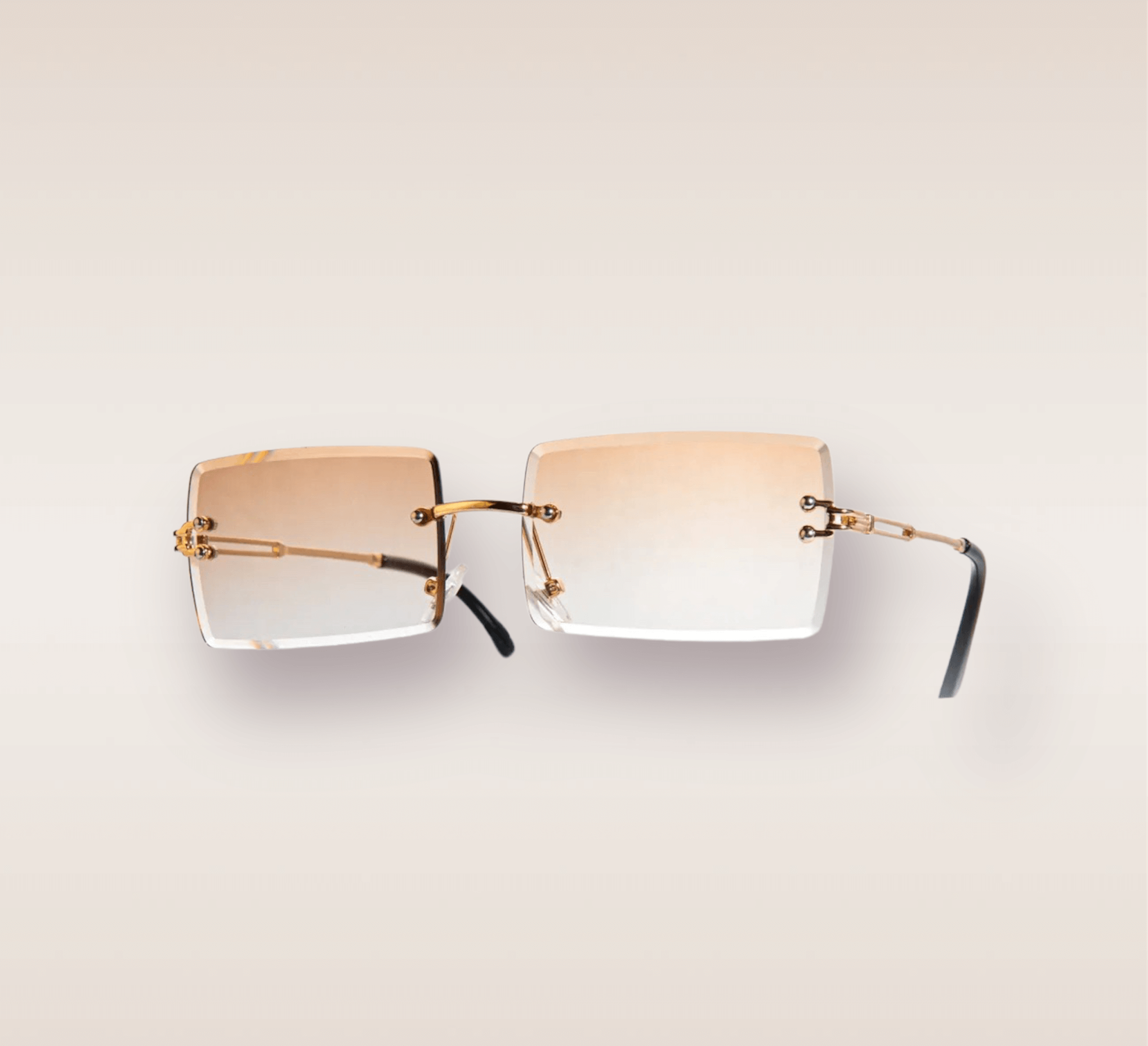 In this up-close shot, we are introduced to the captivating Gradient Tea frames, a stylish and sophisticated eyewear option. The rimless frames feature a mesmerizing light brown gradient hue. The gold arms add a touch of opulence and refinement, complimenting the brown tones with a warm metallic accent. These frames are a true fashion statement, combining modern design with a touch of luxury. 